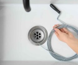 Preparing to do drain cleaning with a drain snake